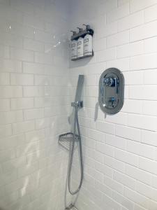 a white tiled bathroom with a shower with aitizer at HighRoad Washington DC in Washington, D.C.