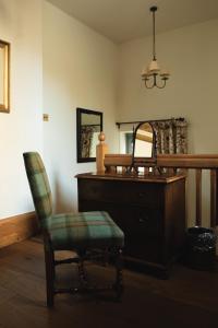 a room with a dresser and a chair and a mirror at Mingary Castle - Restaurant with Rooms in Kilchoan