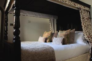 a large canopy bed with pillows on it at Mingary Castle - Restaurant with Rooms in Kilchoan