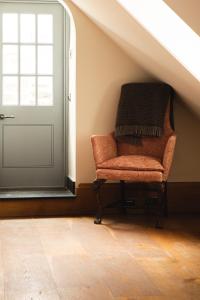a chair sitting in a room next to a door at Mingary Castle - Restaurant with Rooms in Kilchoan