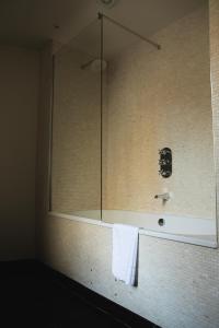 a bathroom with a shower with a white towel at Mingary Castle - Restaurant with Rooms in Kilchoan