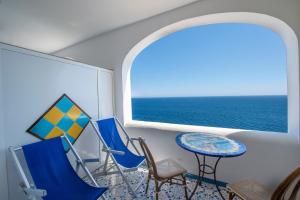a room with chairs and a table and a window at Hotel Costa Diva in Praiano