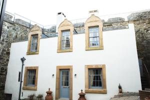 a white house with windows and a blue door at Mingary Castle - Restaurant with Rooms in Kilchoan