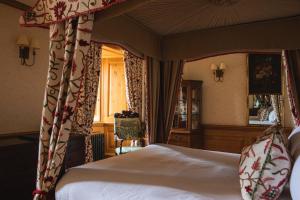 a bedroom with a canopy bed and a window at Mingary Castle - Restaurant with Rooms in Kilchoan