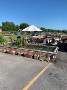 a parking lot with a table and an umbrella at Dolafon Farm Stay in St Asaph