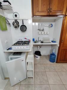 a small kitchen with a stove and a sink at Villa colonial suite n 4 basic interior in Río San Juan
