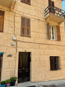 a brown brick building with a door and a balcony at Studio cosy au coeur de Saint Martin Vésubie in Saint-Martin-Vésubie