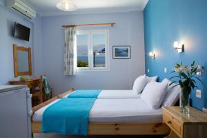 a blue bedroom with a large bed and a window at Jimmy's House in Nikiana