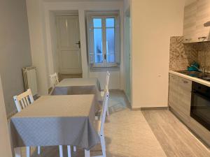 uma cozinha com duas mesas e uma mesa e cadeiras em Il Nido delle Rondini em Formia
