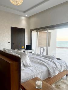a bedroom with a large white bed with a view of the ocean at Paradisiac and luxurious villa with private beach in Dakhla in Dakhla