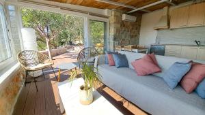 a living room with a blue couch with colorful pillows at Kytherian Harmony - Paleopolis Estate in Avlemonas