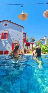 dos mujeres en el agua en una piscina en Banana Alaçatı Wellness Hotel - Adults Only en Alacati