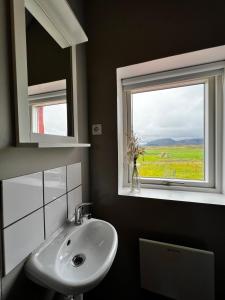 łazienka z umywalką i oknem w obiekcie Sauðanes Guesthouse w mieście Höfn