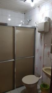 a bathroom with a shower and a toilet and a sink at Pousada Recanto Das Estrelas in São Francisco de Paula