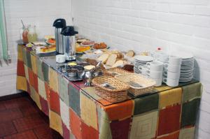 a table with plates and bowls of food on it at Pousada Recanto Das Estrelas in São Francisco de Paula