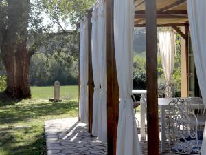 una fila de cortinas blancas en un porche en Belvilla by OYO Villa Pomona, en Ghizzano