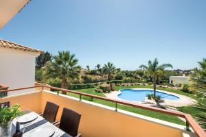 a balcony with a view of a pool and palm trees at Beautiful Two Bedroom Apartment with Roof Terrace in Carvoeiro
