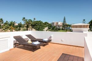a patio with two chairs on a white wall at Modern and Spacious Two Bedroom Apartment in Carvoeiro