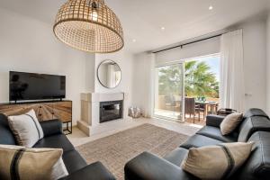 a living room with a couch and a television at Modern and Spacious Two Bedroom Apartment in Carvoeiro