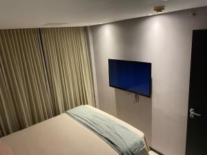 1 dormitorio con 1 cama y TV de pantalla plana en Barra Home stay 22 andar en Recife