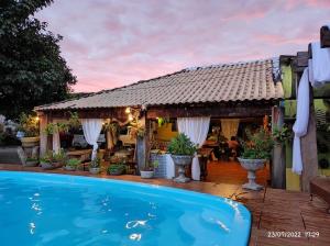 a house with a swimming pool in front of a house at Pousada Cantinho de Casa in Estivado