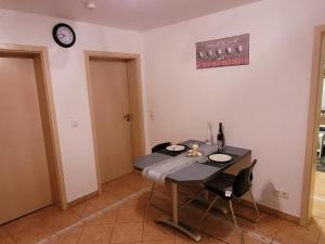 HeidenburgにあるSchöne gemütliche Ferienwohnung im Hunsrückのテーブルと時計付きの部屋 +1枚の写真