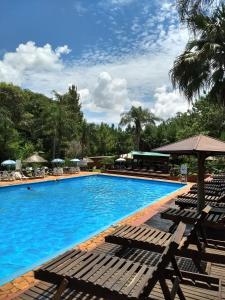 a large swimming pool with chairs and umbrellas at Complejo Don Raúl in Puerto Rico