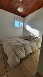 a large bed in a bedroom with a wooden ceiling at Mi lugar in San Carlos de Bariloche