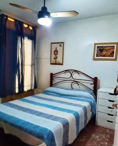 a bedroom with a bed with a blue and white striped blanket at Hostel Otro Mundo in Mendoza