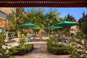 a patio with umbrellas and tables and chairs at Ayres Suites Ontario at the Mills Mall - Rancho Cucamonga in Ontario