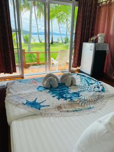 a bedroom with a bed with a view of the ocean at Prompakdee Kohmak Resort in Ko Mak