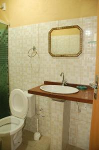une salle de bain avec un lavabo, des toilettes et un miroir dans l'établissement Aguasclaras Residencial, à Manaus