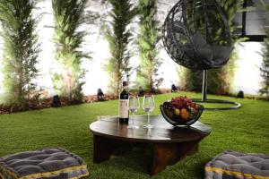 伊拉克利翁鎮的住宿－Damona 2BR Luxury Home with garden - κοντά στο κέντρο，一张桌子,上面放着两杯葡萄酒和一碗水果