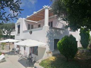 a white church with tables and umbrellas in front of it at La Casa di Pitti in Anacapri