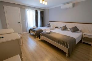 a hotel room with two beds and a window at İcarus Alaçatı in Çeşme +46 photos