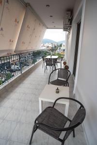 Un balcón con sillas, mesas y vistas. en Chalkis Tropical House en Chalkida