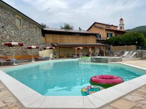 una gran piscina con dos bolas inflables. en Agriturismo Gli Ulivi, en Garlenda