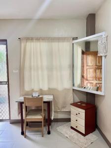 Habitación con escritorio, silla y espejo. en Jo-Cris Apartelle en Isla de Mactán