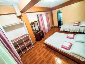 um quarto amplo com 2 camas e um espelho em JO-ZA-NA's Hostel(bed and breakfast) em Baguio