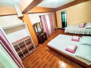 a large room with two beds and a mirror at JO-ZA-NA's Hostel(bed and breakfast) in Baguio