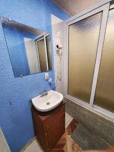 La salle de bains est pourvue d'un lavabo et d'un miroir. dans l'établissement Coco Bahia Apartment, à Six Huts