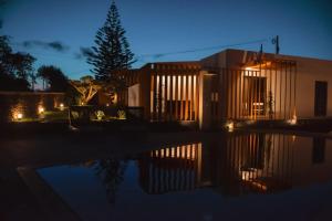 a house at night with a reflection in the water at Vilas do Olival in Ponta Delgada