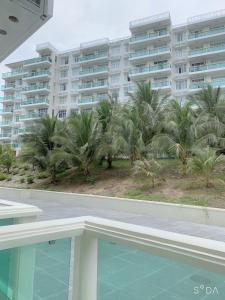 a view of a resort with palm trees and a swimming pool at Comfortable Family Apartment at Sealinks Mui Ne in Ấp Ngọc Hải