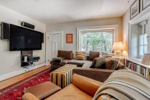 a living room with a couch and a flat screen tv at Four Bedroom Rosedale Home in Toronto