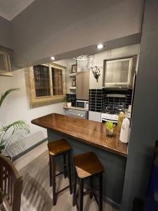 a kitchen with a counter and two stools in it at Departamento Céntrico SJ Boutique in San Juan