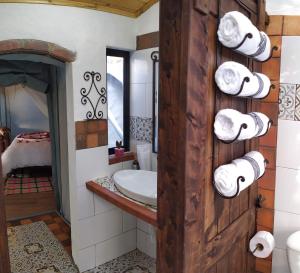 派帕Glamping De Ruana Por Boyacá的墙上设有带水槽和毛巾的浴室