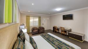 a living room filled with furniture and a tv at Drovers Motor Inn in Dalby