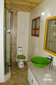 a bathroom with a green sink and a toilet at HOTEL COLONIAL VILLA CARMELA in Tota
