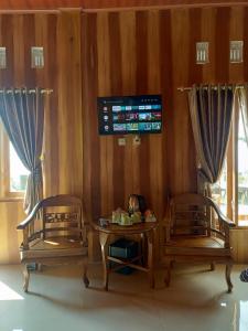 a room with two chairs and a table and a tv at Hotel Agrowisata Kopeng Gunungsari in Kopeng