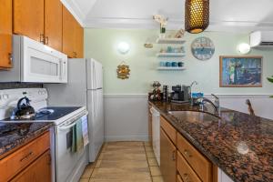 a kitchen with a sink and a stove top oven at Quiet Kiahuna plantation , New Remodel with AC in Koloa